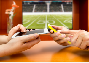 hands with phones trying to place a bet for football